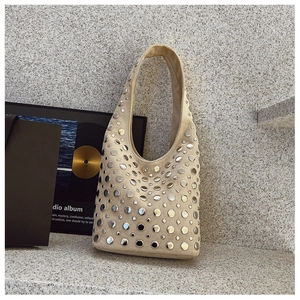 Détail de rivets argentés sur sac hobo en daim beige avec finition métallique élégante