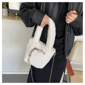 Detail einer weißen Plüschhandtasche mit Perlenakzenten und floralem Seidenschal-Dekor