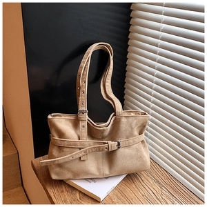 Detail of beige suede tote bag showing the matte texture and silver metal buckle