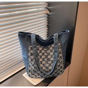 Détail du sac cabas en denim bleu avec motif à carreaux frangés et poignées