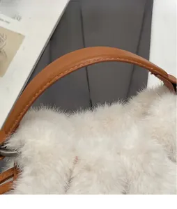 Detail of soft faux fur texture and brown leather handle with premium stitching