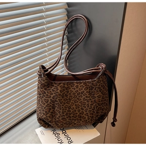 Detailed close-up of leopard print shoulder bag with drawstring side and sleek strap