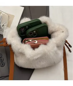 Interior view showing large storage capacity of white plush bucket bag with brown strap
