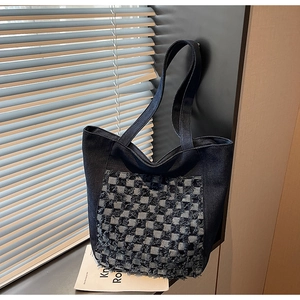 Détail du sac cabas en denim à carreaux montrant la couture damier et les bords effilés