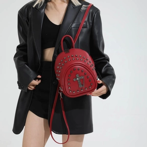 Detail of red rivet mini backpack with punk metal cross and chain on smooth PU leather