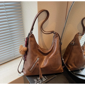 Detailed macro of brown vintage leather bag texture with fringe zipper and bear charm