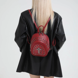 Vintage red leather backpack with silver studs and cross pendant on a model