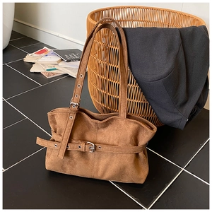 Detailed view of the brown suede tote bag featuring adjustable metal buckle and soft folds