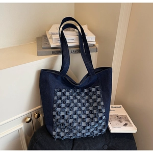 Détail du sac cabas en jean bleu avec motif à carreaux frangés et texture durable