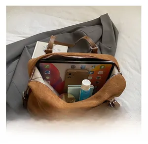 Top view of brown suede Boston bag showing large interior capacity for tablet and essentials