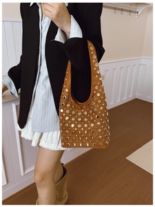 Détail du sac hobo en daim marron vintage avec des rivets argentés de style bohème