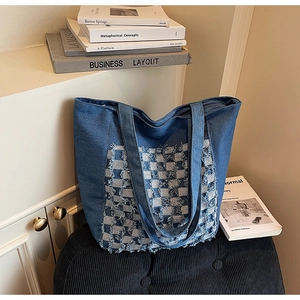 Détail du sac cabas en jean montrant le patchwork à carreaux avec franges et bandoulières