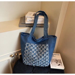 Vue détaillée du sac cabas en denim avec un motif à carreaux bleus et blancs texturés