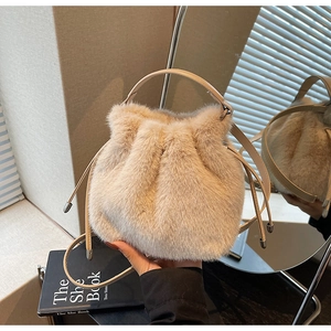 Close-up of fluffy faux fur bucket bag with drawstring closure and leather handle