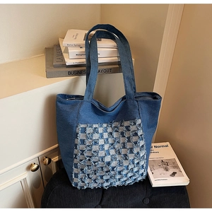Détail du sac cabas en denim à carreaux bleu et blanc avec anses tissées robustes
