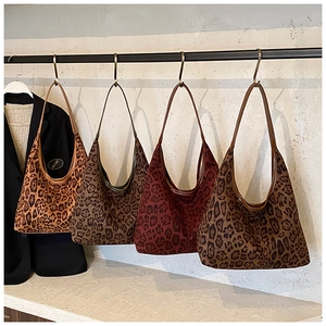 Detailed display of four leopard print tote bags in varied shades with leather straps