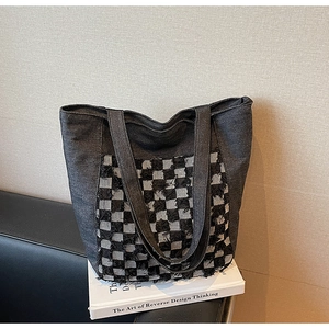 Détail du cabas en denim avec écusson à carreaux vintage et texture en jean robuste