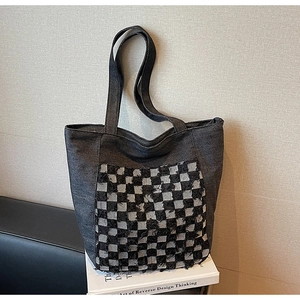 Vue détaillée du sac cabas en denim gris avec patchwork à carreaux et bords effilochés