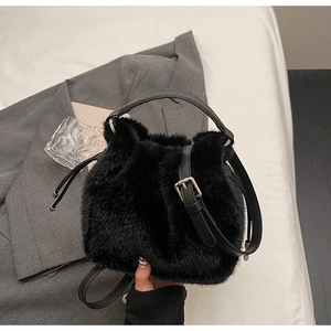 Close-up of black faux fur bucket bag featuring drawstring closure and leather handle