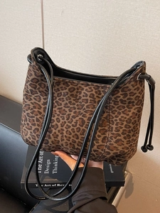 Fashionable leopard print shoulder bag with black strap and soft faux fur texture