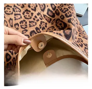 Detail of the magnetic closure and leather trim on this vintage leopard print tote bag