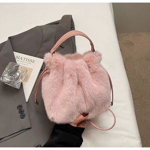 Detail showing plush pink faux fur texture and leather straps on the fashion bucket bag