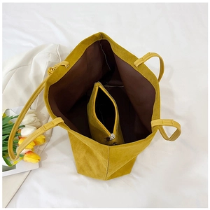 Macro view of ginger yellow suede tote bag with matching zippered inner pouch