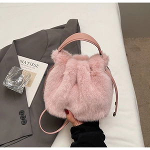 Detailed shot of pink plush bucket bag texture with drawstring closure and leather handles