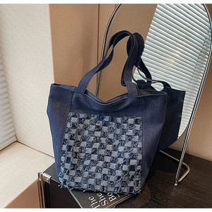 Détail du sac cabas en jean bleu marine avec motif à carreaux effilochés et anses larges