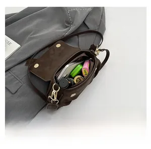 Macro view showing the spacious interior of the brown leather saddle bag with accessories
