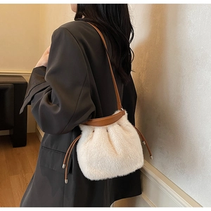Detail of plush bucket bag with white faux fur, brown leather straps, and drawstring closure