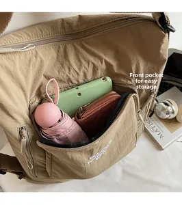 Close-up of khaki nylon shoulder bag front pocket showing large storage capacity