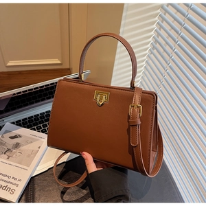 Détail du sac cabas en cuir caramel avec serrure dorée et bandoulière réglable