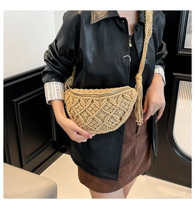 Detail of bohemian woven half-moon crossbody bag with tassel and textured straw pattern
