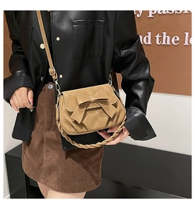 Detail of khaki frosted crossbody bag featuring oversized bow and braided handle