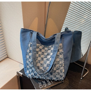 Détail du cabas en denim à damier présentant des franges et des anses robustes