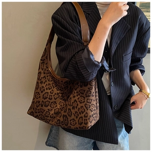 Detail of vintage leopard print shoulder bag with brown leather strap worn on shoulder