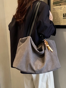Retro grey oversized hobo bag with ethnic tassel charm and slim black straps