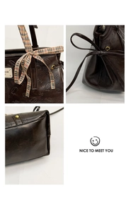Detail view of coffee brown faux leather tote with embossed cartoon pattern and plaid ribbon