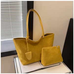Detail view of yellow suede tote bag set with matching zipper pouch on a white cart