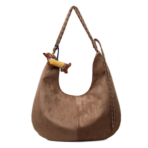Brown suede hobo bag with a braided rope shoulder strap and a cute dog plush charm