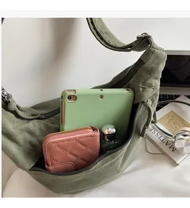 Interior view of army green canvas crossbody bag showing spacious storage for a tablet
