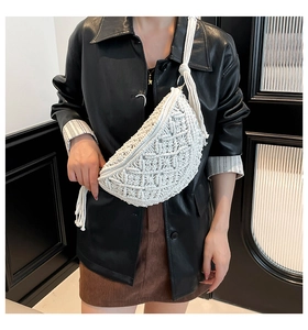Detail of white handmade macrame crossbody bag with fringe on a leather jacket