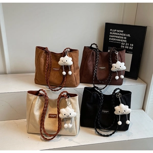 Group display of four suede tote bags with woven handles and plush cloud charms