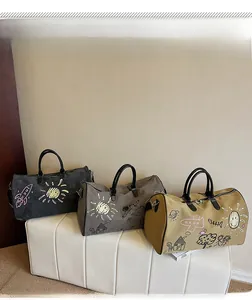 Detailed display of large travel bags with playful graffiti prints in three colors