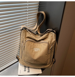 Detail of khaki waterproof nylon backpack with zipper pockets and shadow lighting