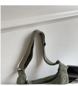 Macro detail of military green canvas bag featuring sturdy handle and metal buckle