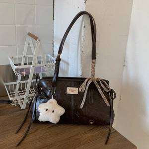 Detail of vintage brown tote bag with cat pattern embossing and star plush pendant