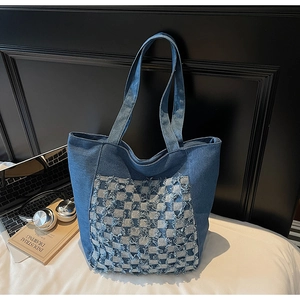 Détail du sac cabas en jean bleu avec motif à carreaux effiloché et doubles anses