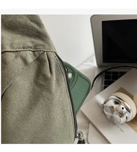 Detailed macro view of an army green canvas bag side pocket holding a smartphone